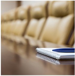 A generic board meeting dais with empty seats behind it.Shutterstock.com